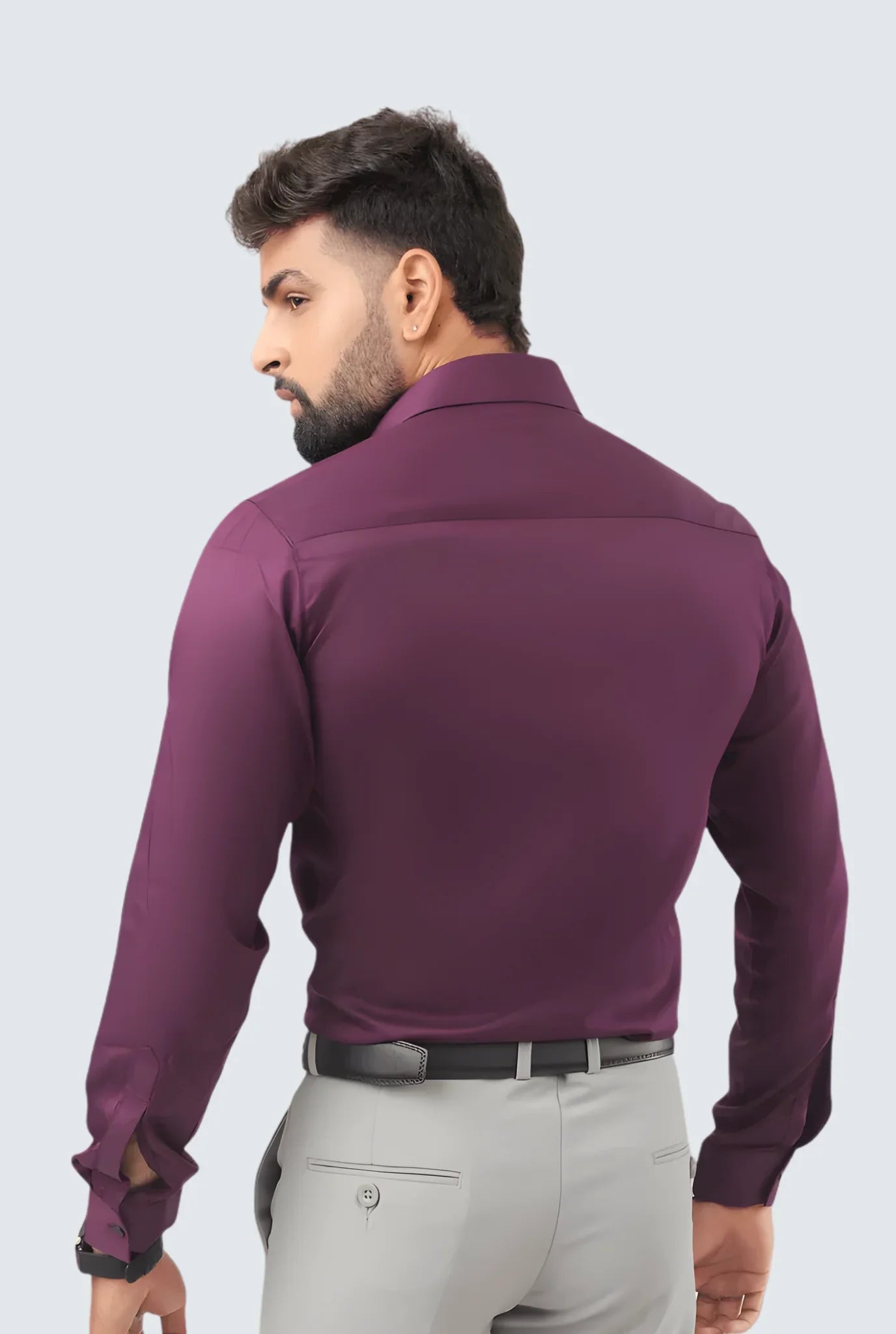 Man wearing purple formal shirt and light grey pants with black belt, back view