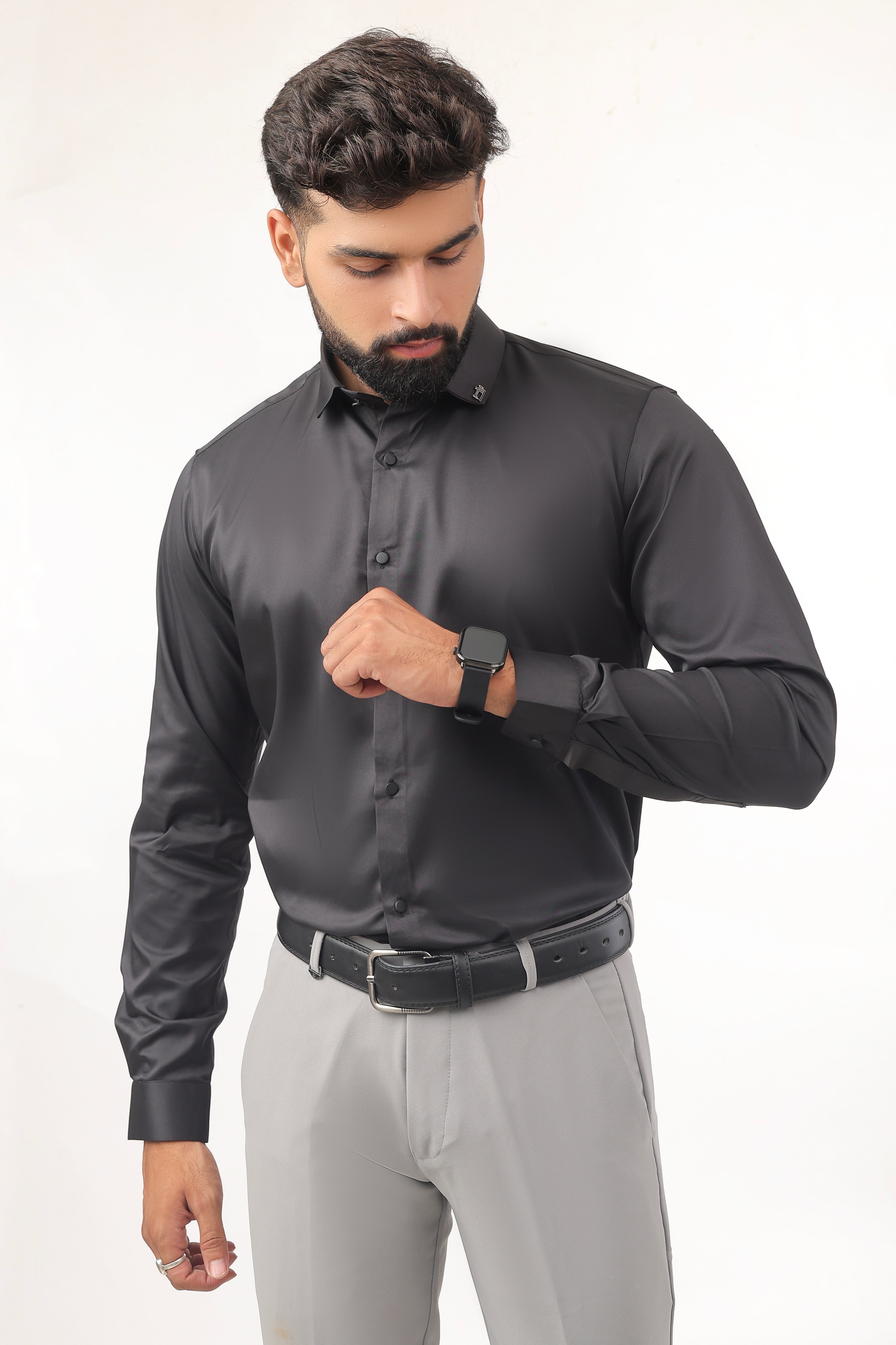 "Model in black satin shirt posing front-facing with arms crossed in a bold stylish posture."