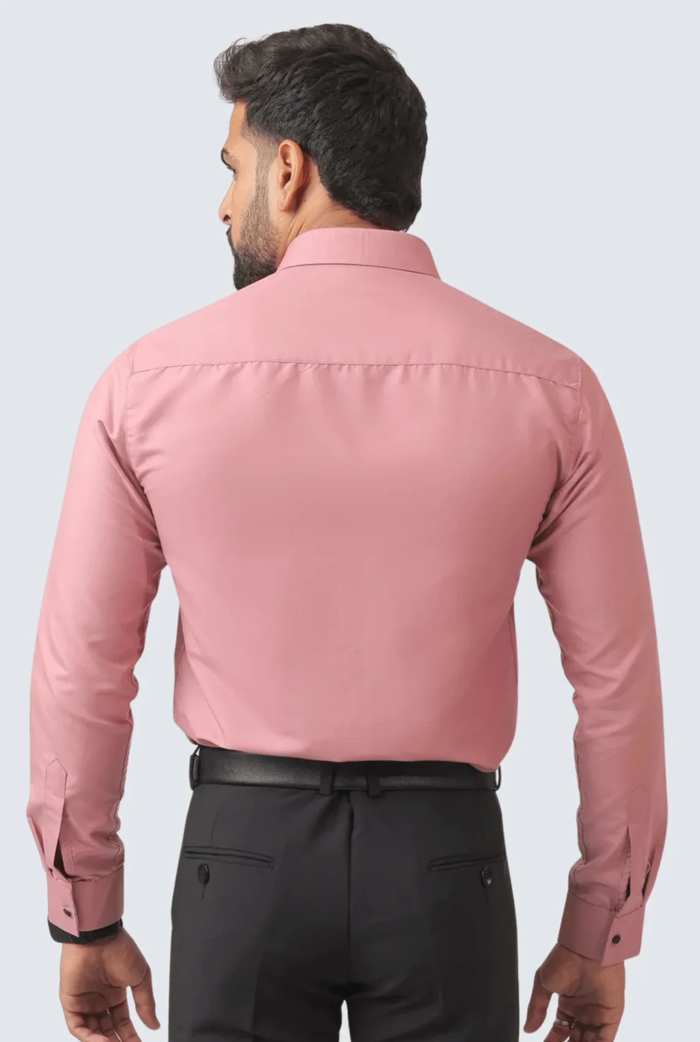 Back view of man wearing a slim fit pink cotton formal shirt with black trousers and belt