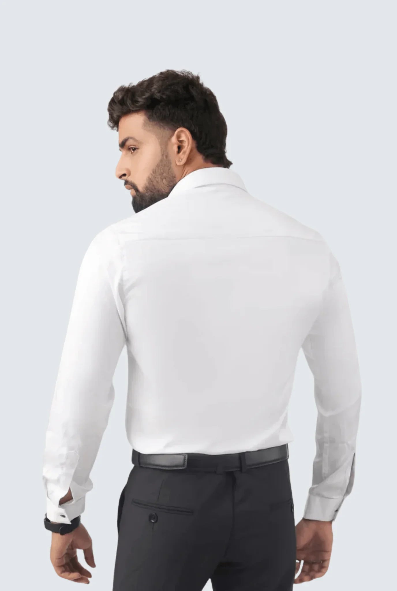 Man wearing white satin long-sleeve shirt and black trousers, shown from back