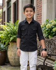 Boys black cotton shirt with chest pockets, worn with white cargo pants