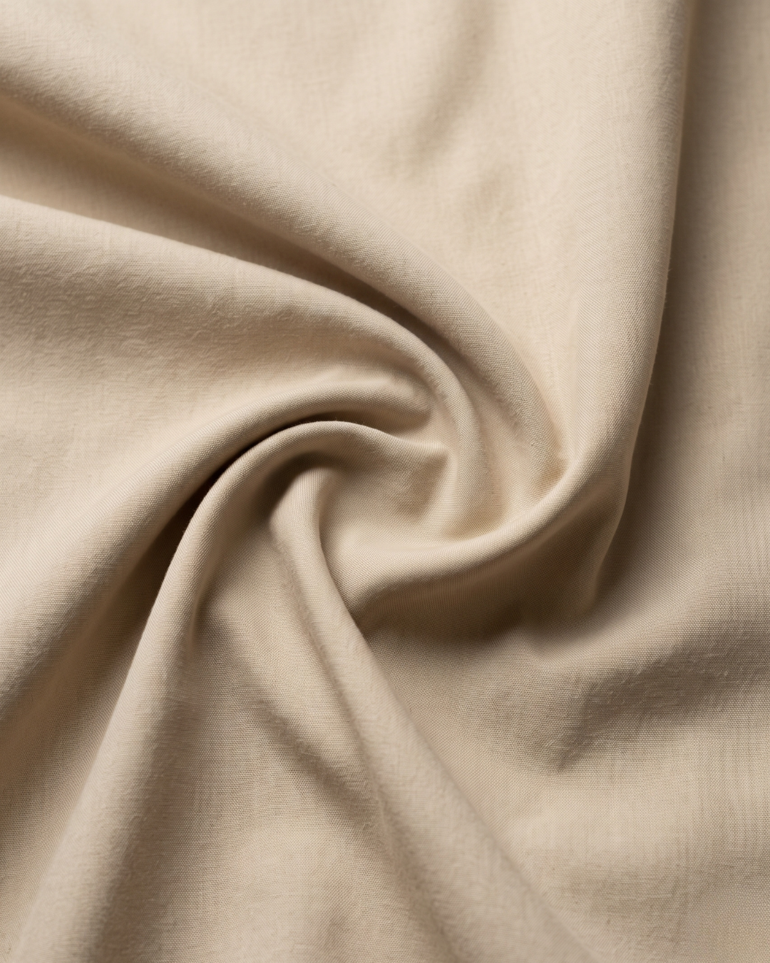 Cream cotton shirt fabric close-up with soft drape