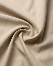 Cream cotton shirt fabric close-up with soft drape