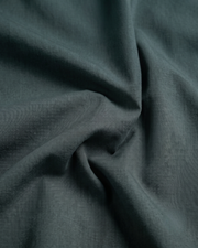 Bottle green cotton fabric close-up with subtle weave texture
