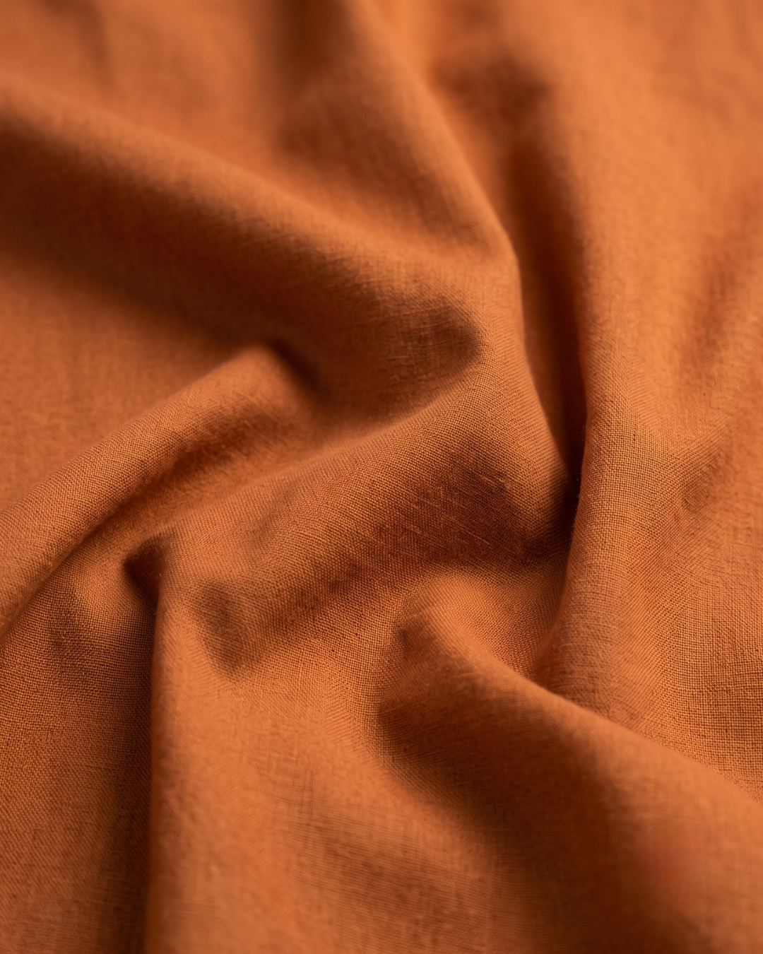 Golden-orange cotton shirt fabric close-up, smooth woven texture