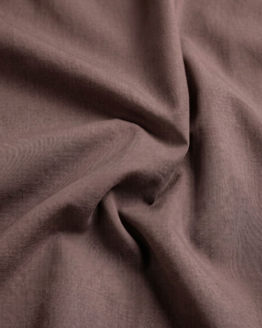 Dusty rose cotton shirt fabric close-up, soft woven texture.