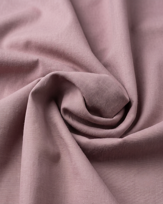 Mauve cotton fabric close-up with smooth woven texture and slight folds.