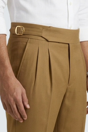 Men's golden-brown pleated trousers with adjustable belt and front crease seams