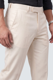Cream regular-fit pants close-up: zip fly, belt loops, and stitched seams
