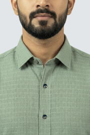 Men's green textured button-up shirt collar with dark buttons