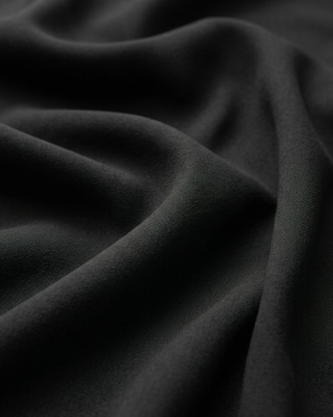 Black shirt fabric close-up with smooth, flowing drape