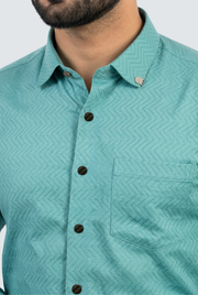 Men's slim-fit dobby cotton shirt in teal, button placket and geometric pattern close-up.
