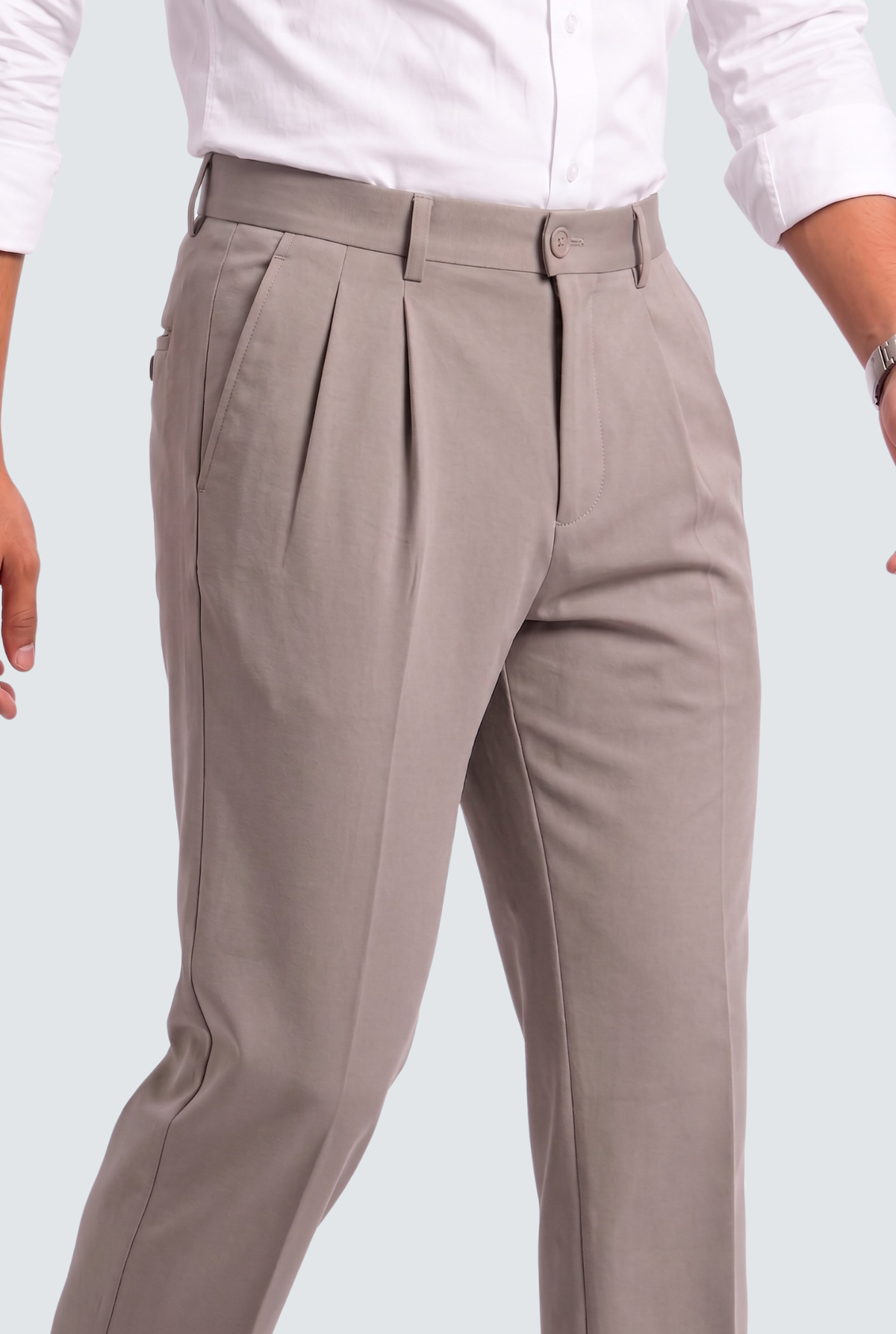 Light gray tailored trousers with pleated front, belt loops, and side pockets