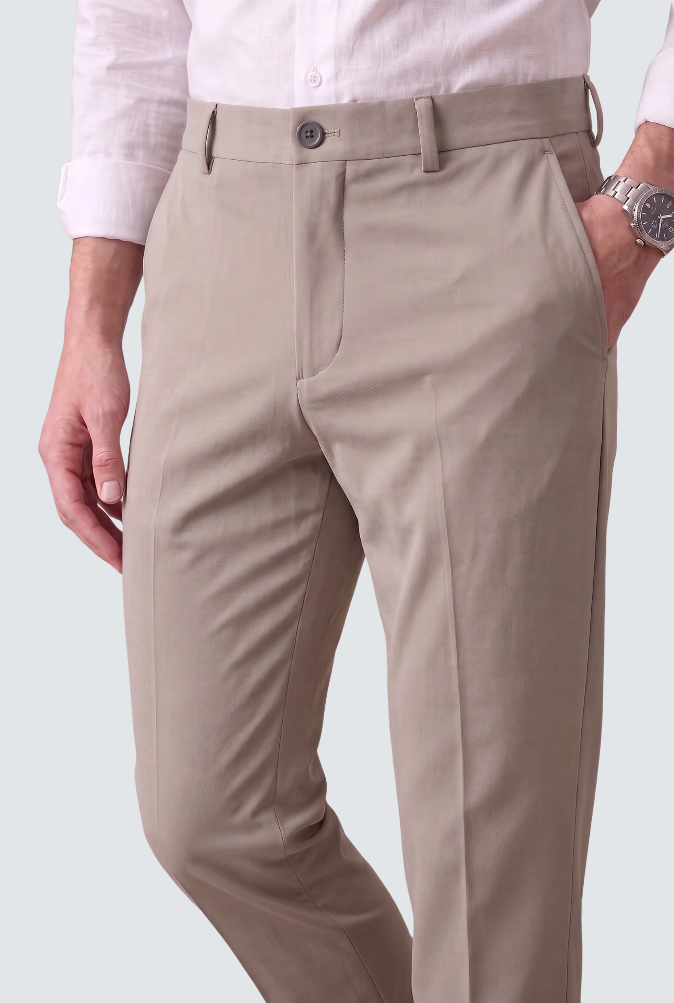 Men's light grey slim-fit trousers, close-up of waistband with button and front pleat
