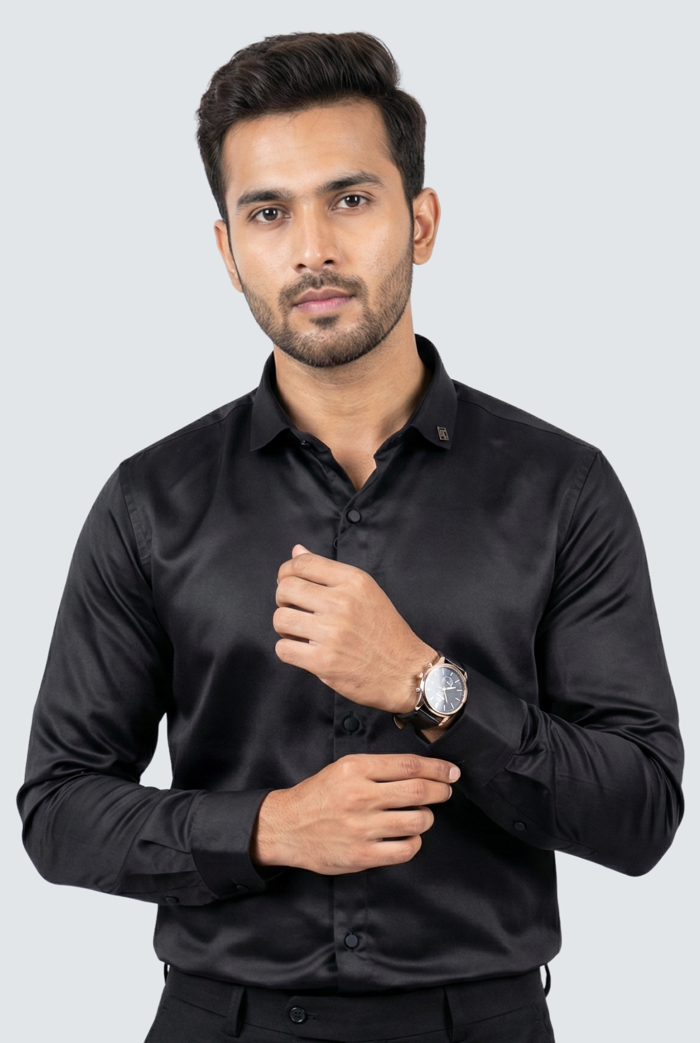 Man wearing a black satin shirt against a light gray background