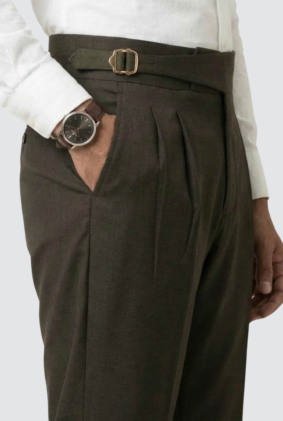 Men's brown trousers with belt and buckle detail, pleated waistband, side pockets.