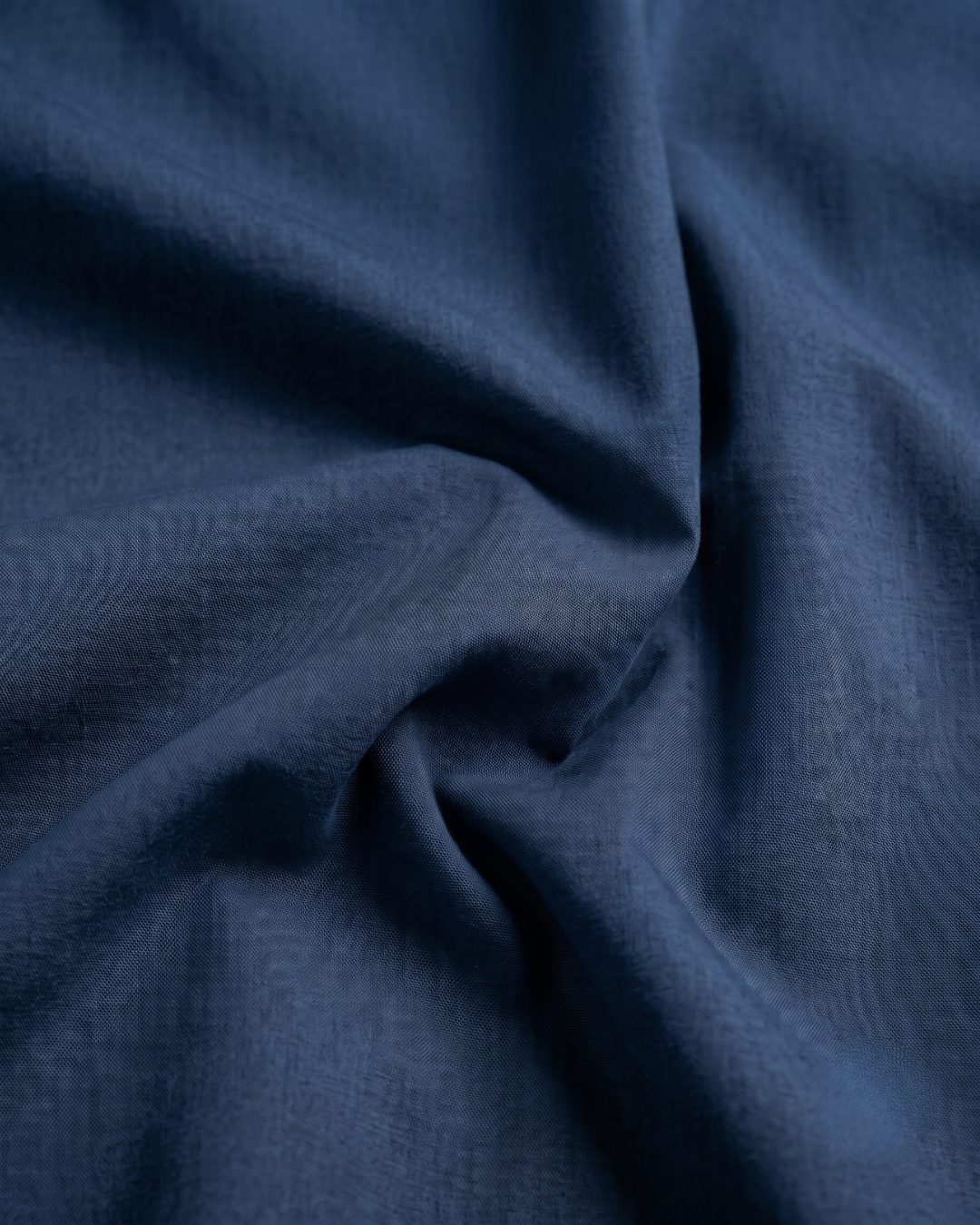 Close-up of navy cotton shirt fabric with soft drape