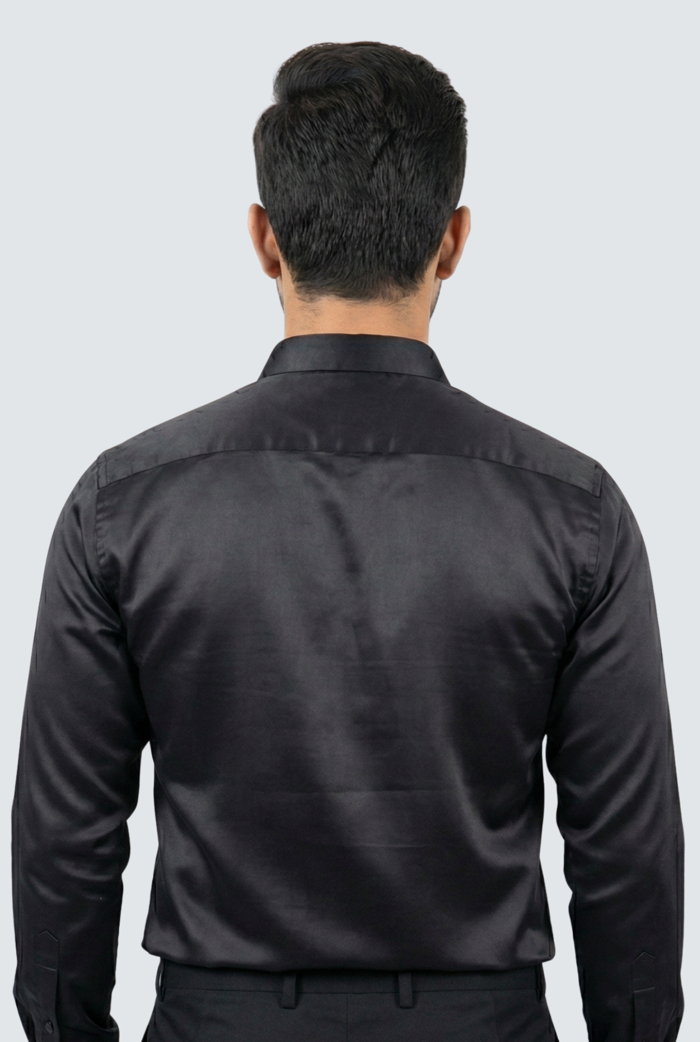 Man wearing a black shirt from behind on a light gray background
