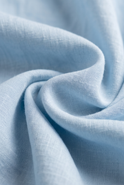 Light sky blue linen fabric close-up, textured weave
