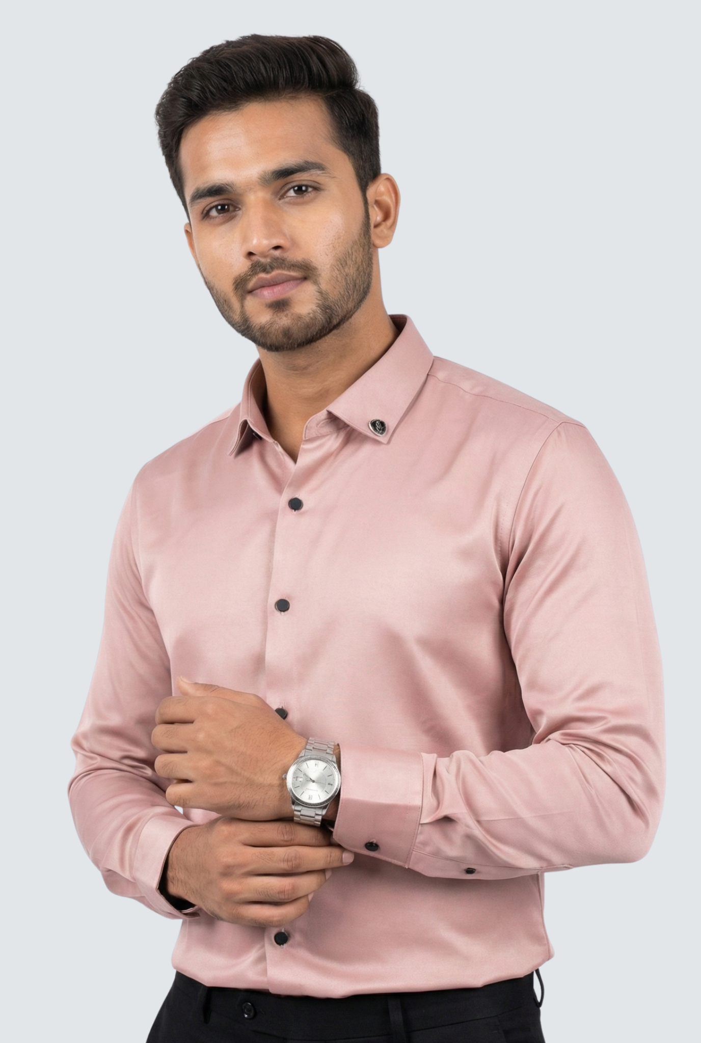 Man wearing a light pink shirt with black buttons on a white background