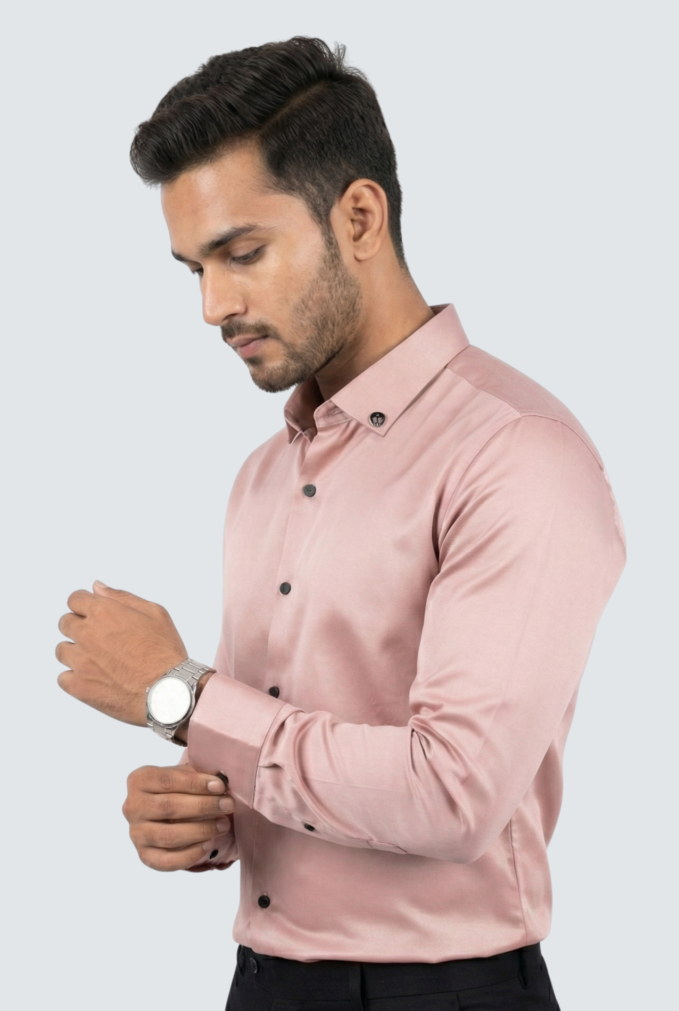 Man wearing a light pink shirt with black buttons on a white background