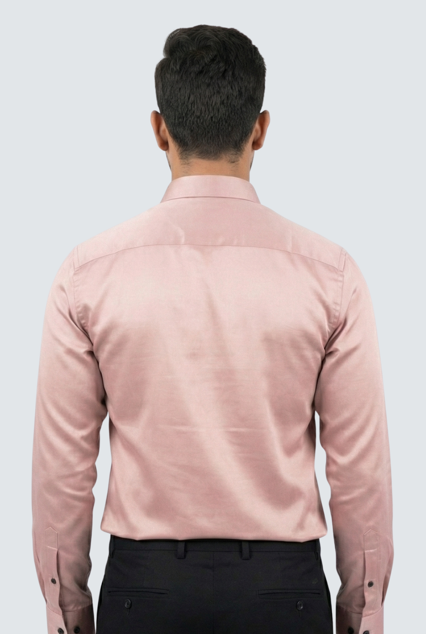 Person wearing a light pink shirt with black pants on a white background
