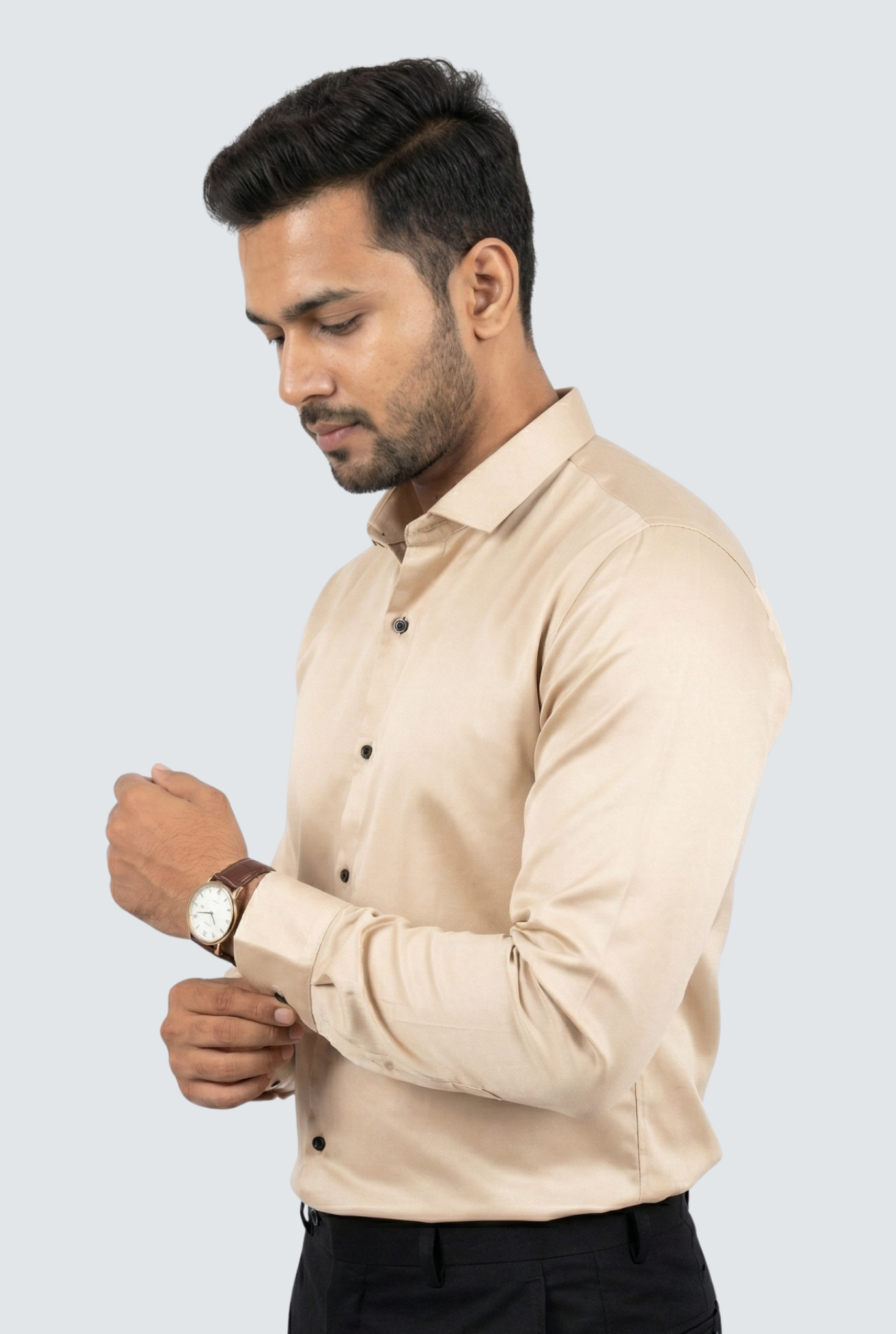 Man wearing a beige shirt and black pants against a light gray background