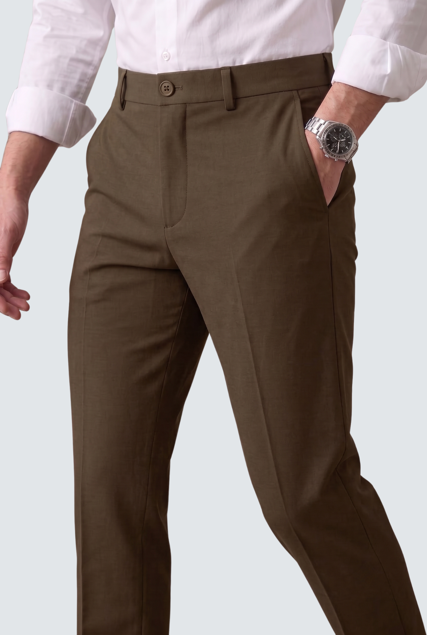 Brown slim-fit regular trousers close-up showing waistband, button, and front pockets