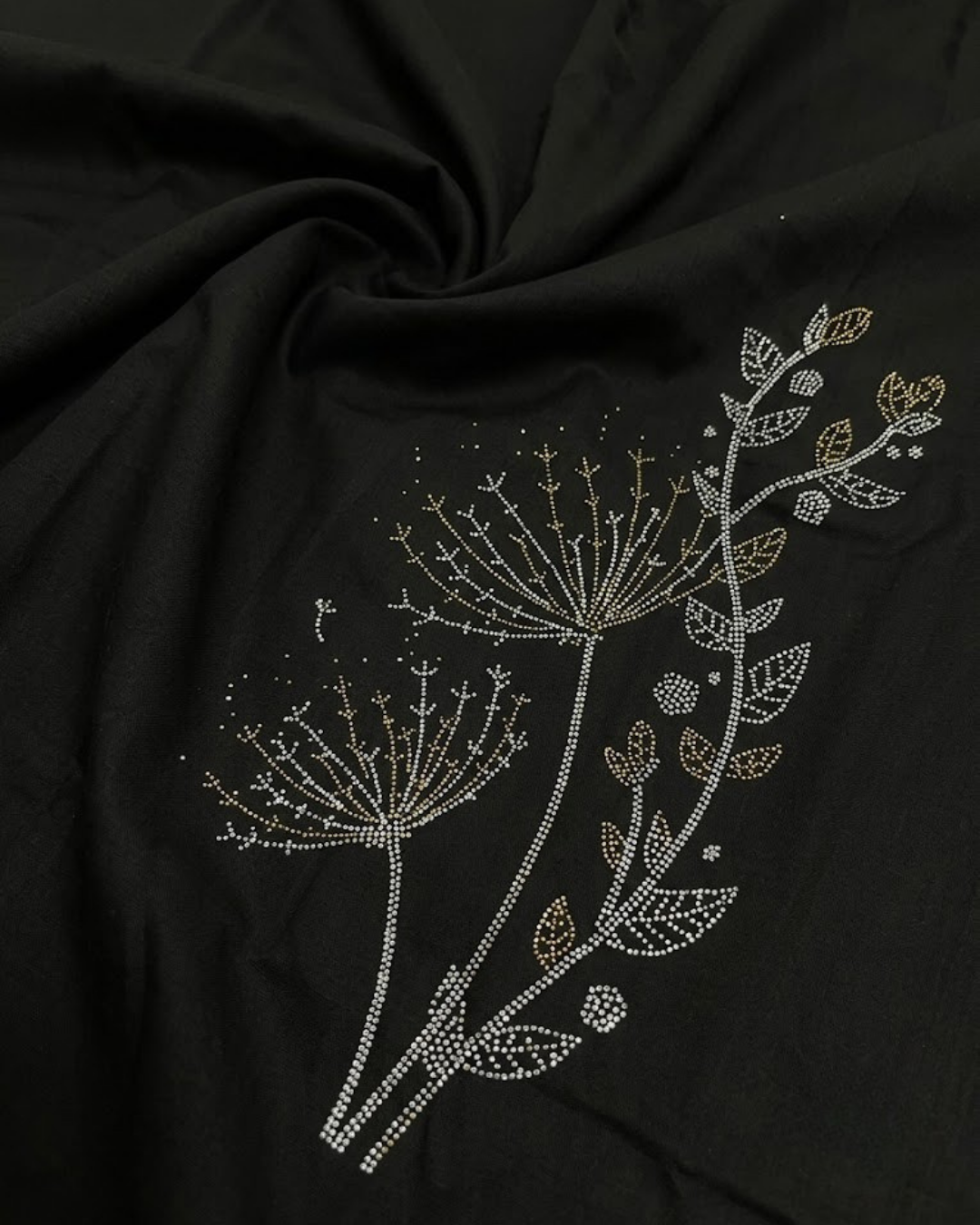 Close-up of black satin lycra shirt with gold floral and leaf embroidery pattern