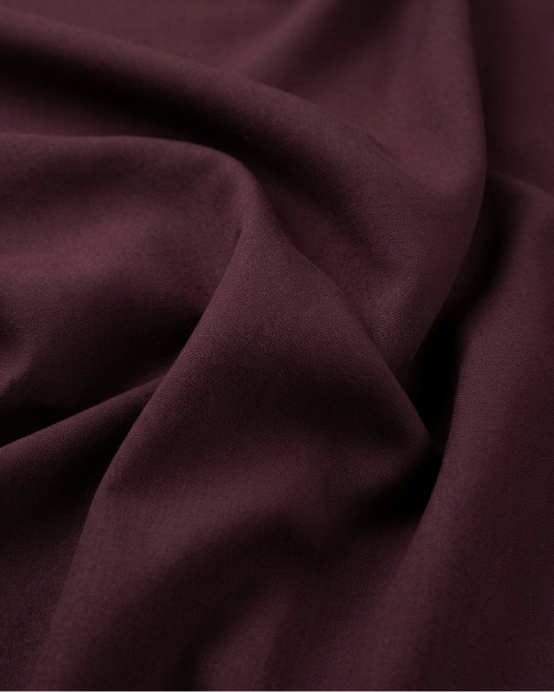 Maroon shirt fabric close-up showing smooth textured weave and drape