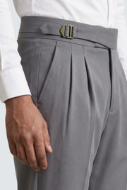 Men's grey trousers waistband close-up with belt buckle and pleats