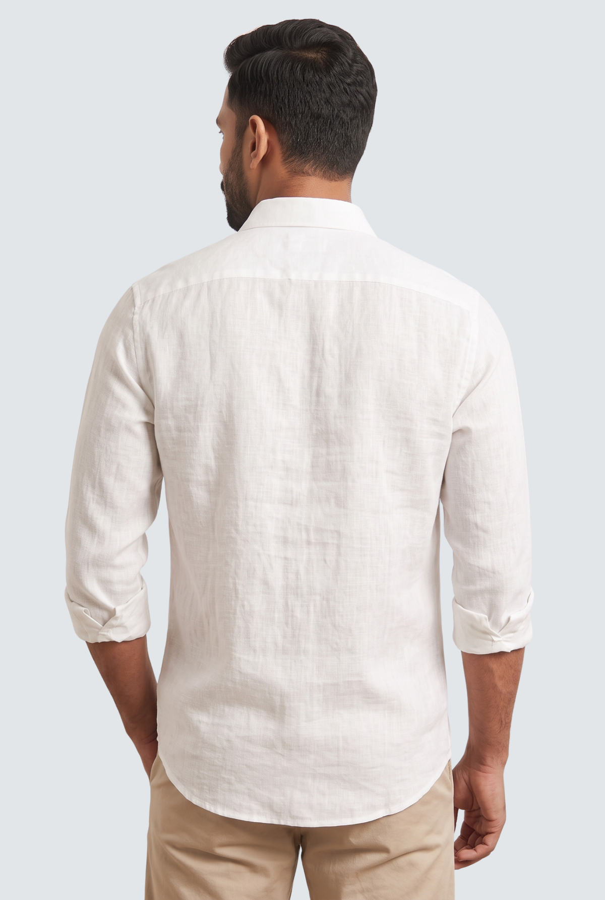 White linen button-up shirt, back view with yoke and folded sleeves.