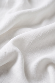 White linen fabric close-up with visible weave texture.
