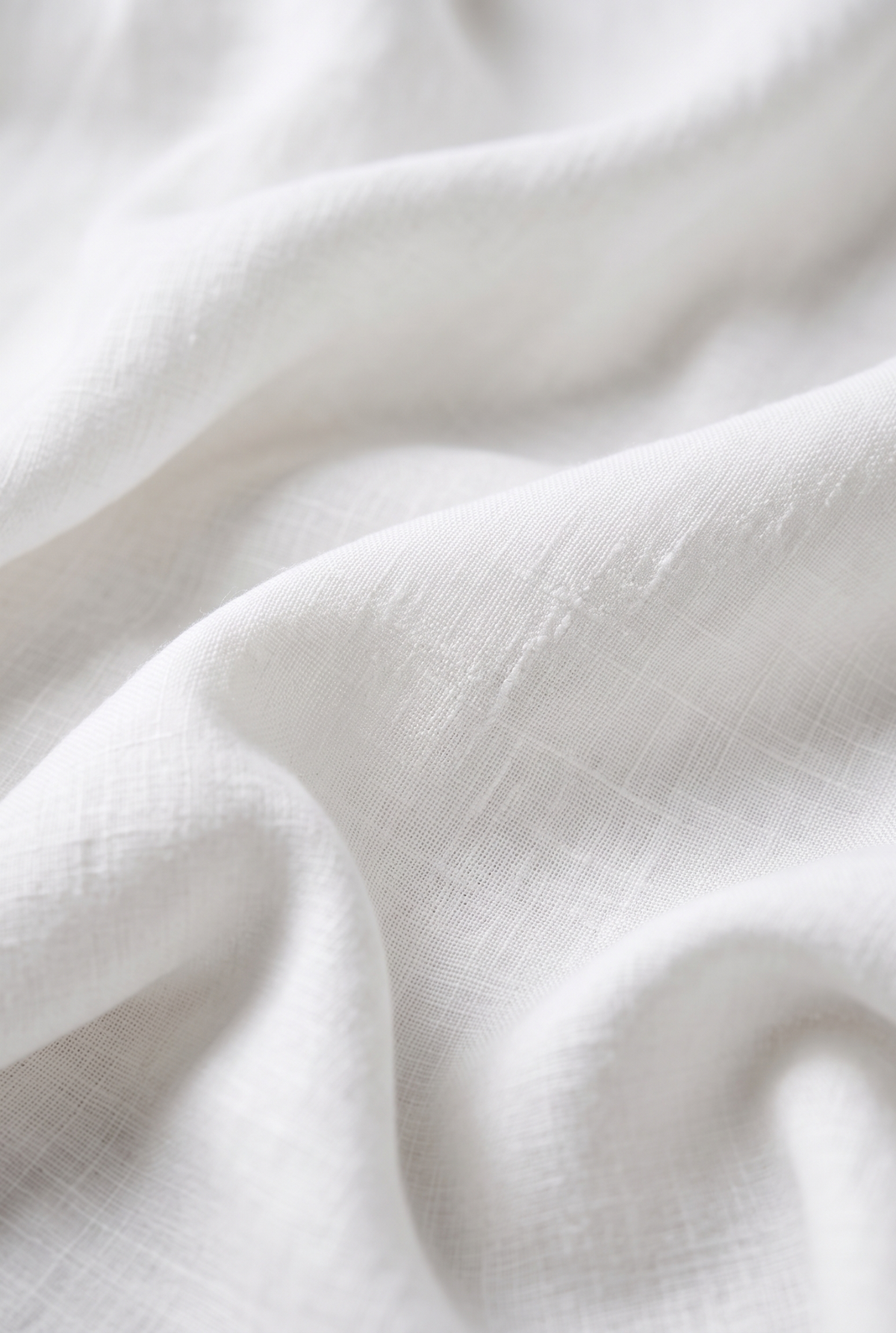 White linen fabric close-up with visible weave texture.