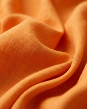 Orange linen fabric close-up with visible weave texture