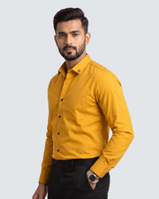 Yellow cotton button-up shirt with long sleeves and chest pocket, side view
