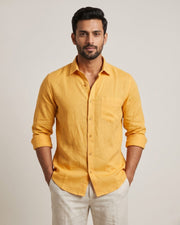 Front view of a yellow linen shirt with a chest pocket and rolled sleeves