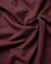 Maroon cotton fabric close-up with soft textured weave