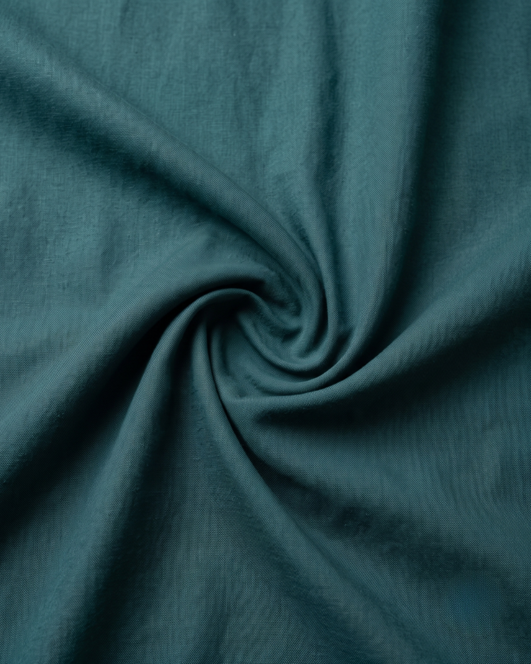 Teal cotton shirt fabric close-up with smooth weave texture