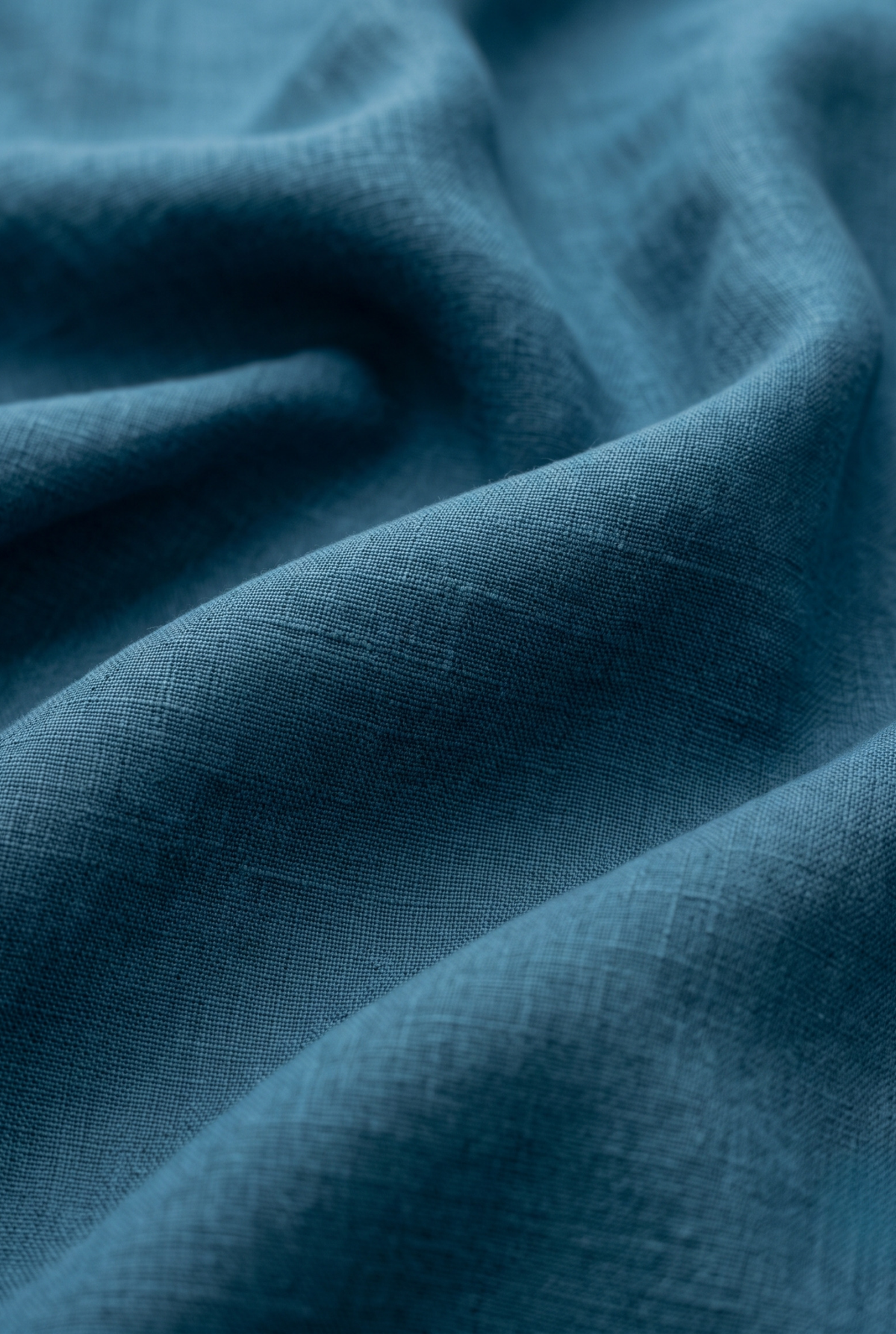 Teal blue linen fabric close-up with fine woven texture